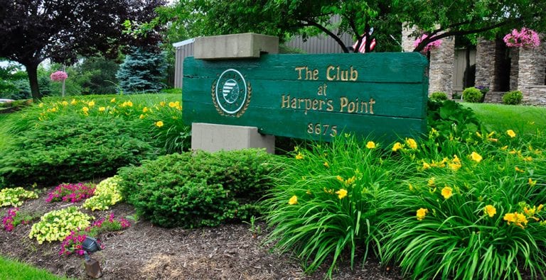 lush landscaping with The Club at Harper's point signage