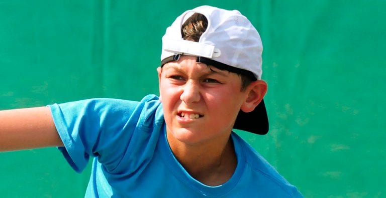 boy with a hat playing outdoor tennis