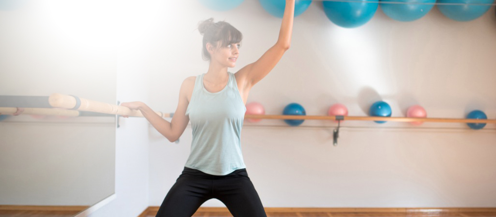 female gym member participating in barre group classes at gym