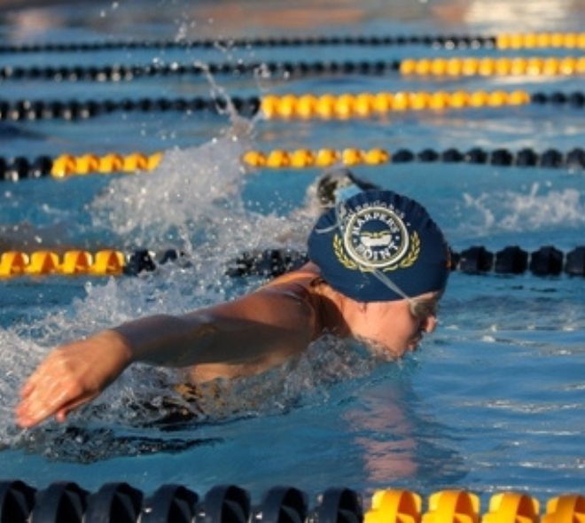 a junior swimmer competing in an outdoor swim competition at the club at harpers point swim club near me